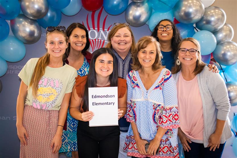 A group of teachers smile